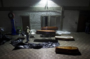 Homem observa caixões dentro da boate Kiss