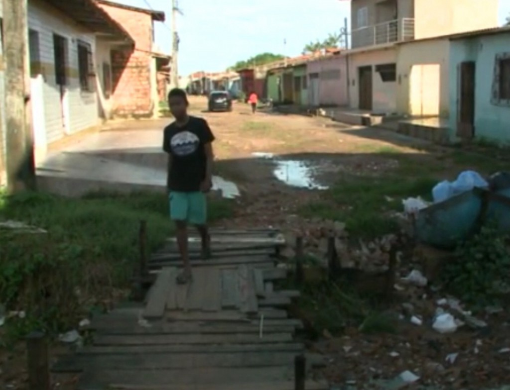 Morador atravessando a ponte de madeira.